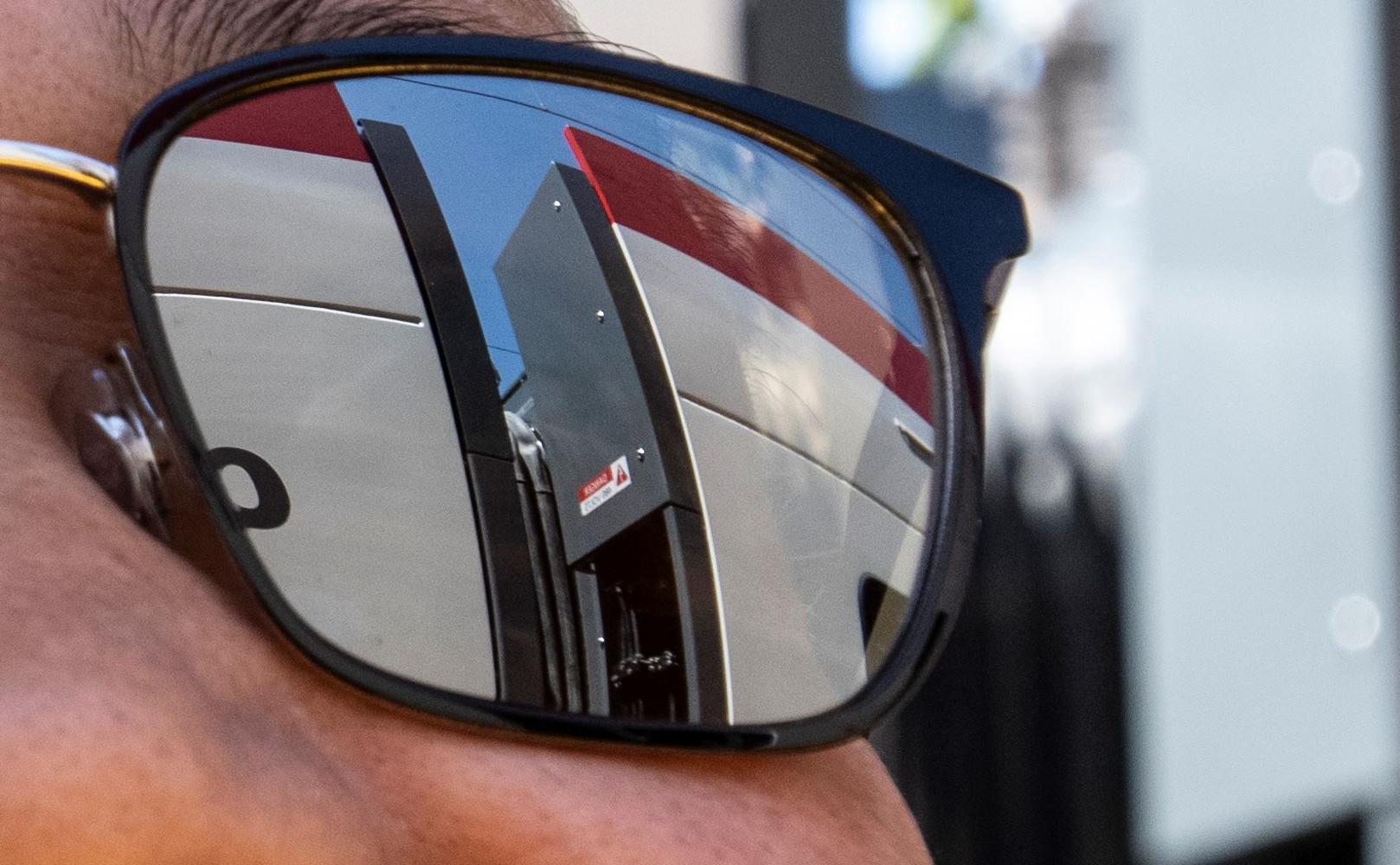 Excited man wearing sunglasses gazes admiringly at the new electric trains