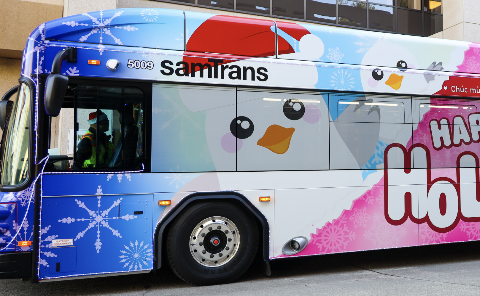The SamTrans Holiday Bus with the Board of Directors and General Manager/CEO April Chan standing in front.