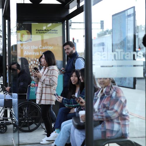 Crowd waits for bus at SamTrans bus stop